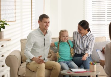 Family on appointment with child psychotherapist indoors
